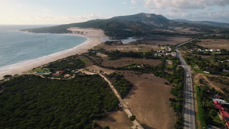 amplia vista aérea del océano, las tierras de cultivo rurales y la carretera principal en tarifa, españa