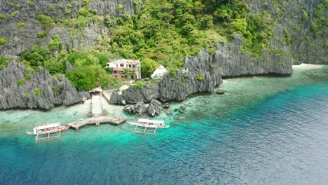 Beautiful-Mantiloc-Shrine-resort-hidden-behind-giant-gray-rocks-and-green-trees-with-an-amazing-view-on-the-clear-blue-ocean-at-Mantiloc-Island-near-El-Nido-in-the-Philippines