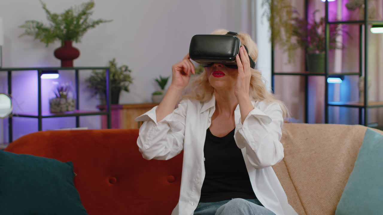 mujer de la tercera edad usar realidad virtual tecnología futurista auriculares jugar simulación 3d videojuego en casa