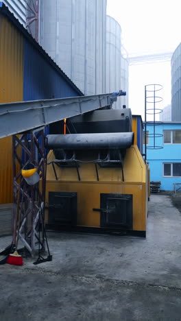 exterior of the elevator furnace premises with a long orthogonal tube. view of the exterior with gradual distancing. huge tanks at the backdrop. vertical video
