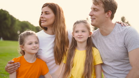 porträt einer glücklichen familie, die etwas interessantes umarmt und betrachtet, während sie gemeinsam zeit im park verbringen 1