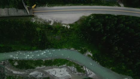 Drone-Volando-Sobre-Un-Río-De-Montaña-Al-Lado-De-Una-Carretera-Protegida