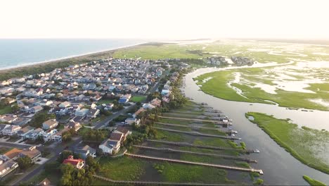 drone shot of ocean isle beach at sunset near the causeway overlooking piers and houses on the waterway