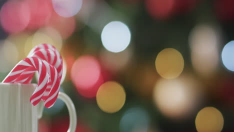 Video-of-white-mug-with-christmas-cnady-canes-and-christmas-tree-lights-with-copy-space