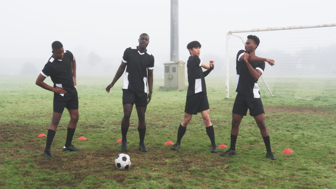 Soccer players warming up on foggy field, preparing for practice session