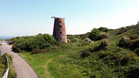 Amlwch-port-red-brick-disused-abandoned-windmill-aerial-view-North-Anglesey-Wales-rising-from-pathway