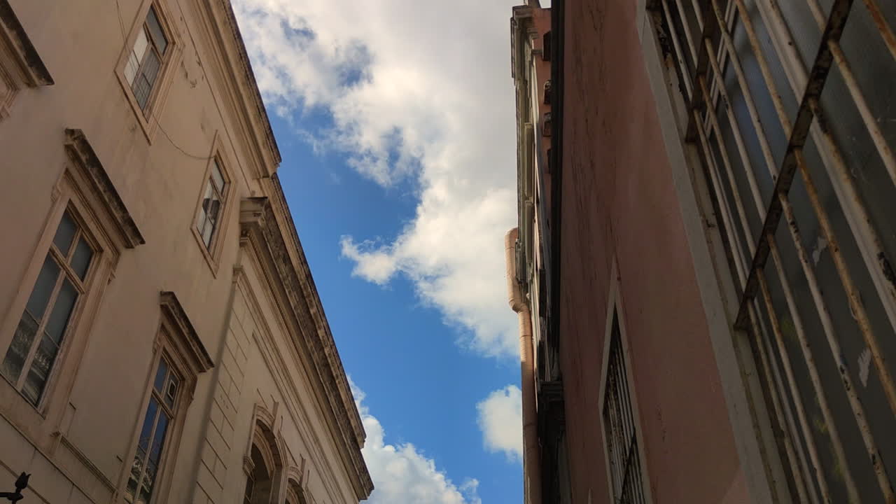 cielo azul con nubes blancas entre edificios antiguos - ángulo bajo, lapso de tiempo