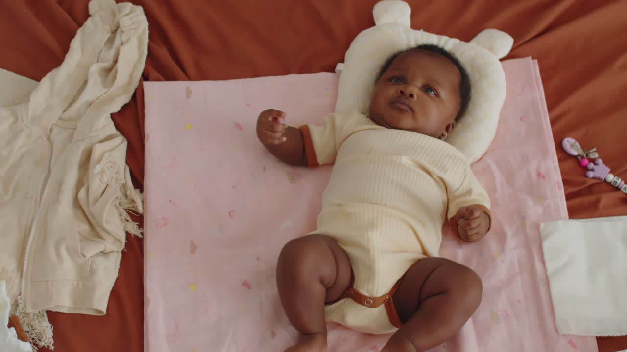 Black Newborn Baby Resting on Pastel Pink Blanket