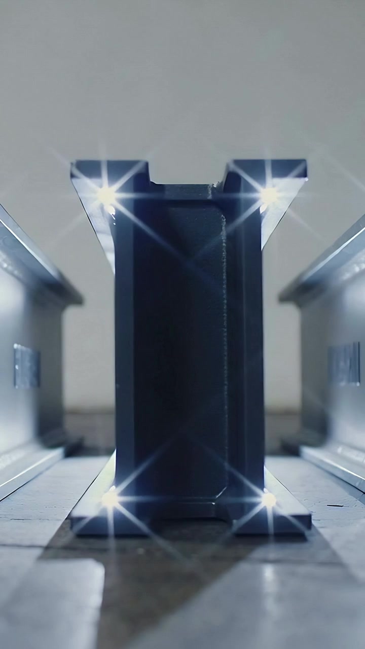 Video verticale: LED angolari pulsanti che illuminano una trave d'acciaio a doppia T tra le rotaie sul cemento, con bagliori