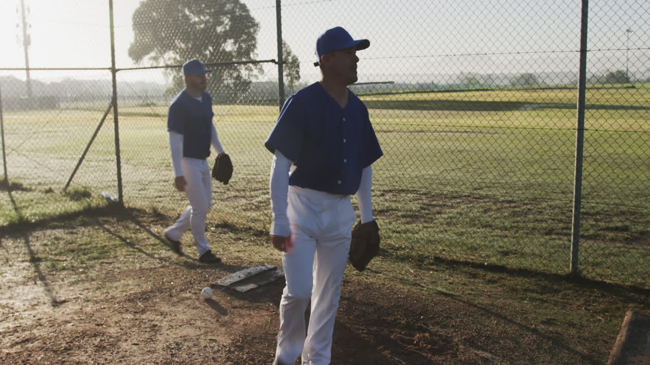 Giocando a baseball, un lanciatore si prepara a lanciare la palla mentre un compagno di squadra osserva.