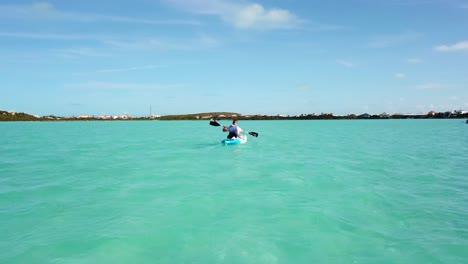 kayaker in the turquoise blue ocean off the coast of providenciales in the turks and caicos archipelago