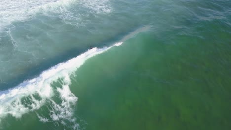 drone flight following a surfer on waves in cascais, europe