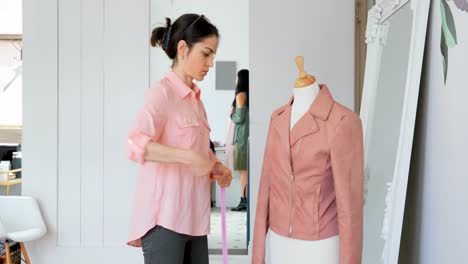 Fashion-designer-measuring-the-jacket-on-dressmakers-model-4k