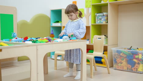 Child-Little-Girl-Stack-Building-Blocks-Making-Wall-in-Playroom---full-shot