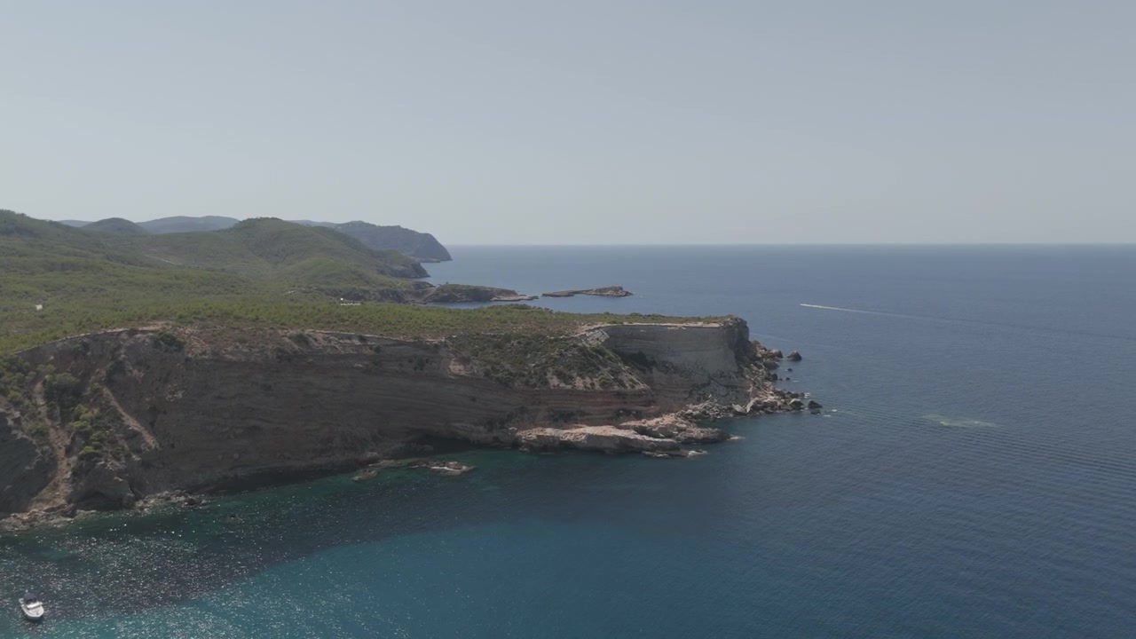 Portinatx yakınlarındaki büyüleyici Ibiza kıyı şeridini berrak mavi sular ve kayalık falezlerle, canlı renklerle, atmosferik aydınlatmayla ve dinamik hareketle yakalayan drone çekimi