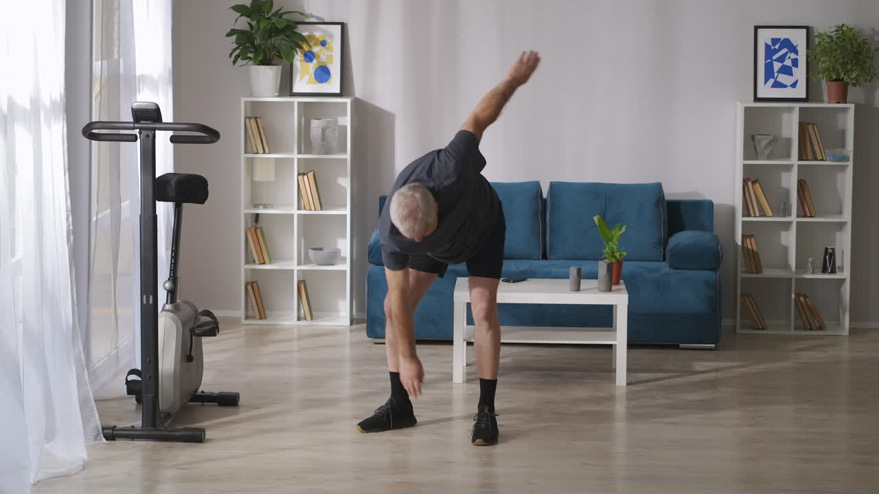 hombre de mediana edad está entrenando en casa por la mañana inclinaciones y ejercicios de estiramiento gimnasia para las articulaciones estilo de vida de salud en la mediana edad