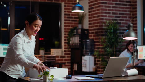 Woman-dancing-and-singing-while-packing-desk-belongings