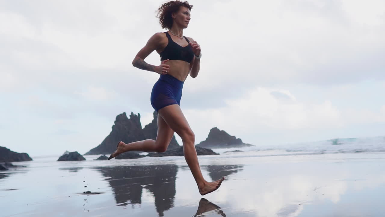 A Journey to Fitness: Slow Motion Beachside Run of a Curvaceous Athlete with Morning Clouds
