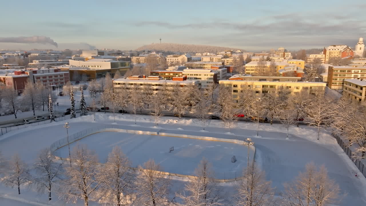 Aerial tracking shot of a ice hockey rink in Kuopio, winter sunset in Finland