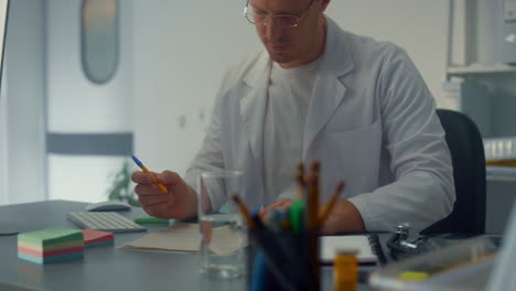 Serious-physician-working-hospital-close-up.-Man-doctor-using-computer-online.