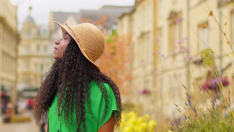 female tourist wearing straw sun hat on vacation in oxford uk exploring city walking along broad street