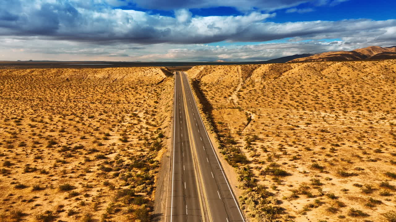 Footage above the highways in Nevada desert, USA. Gorgeous cloudscape in the sky at backdrop. Top view.