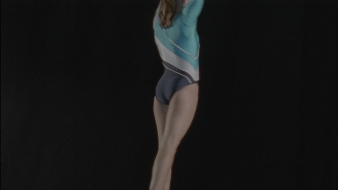 uma ginasta executa uma rotina em uma barra de equilíbrio