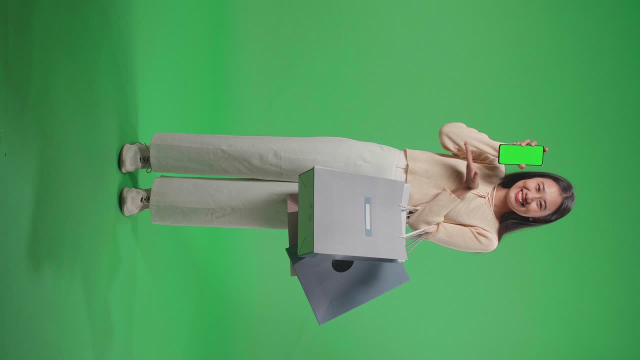 mujer con bolsas de compras y teléfono inteligente en la pantalla verde