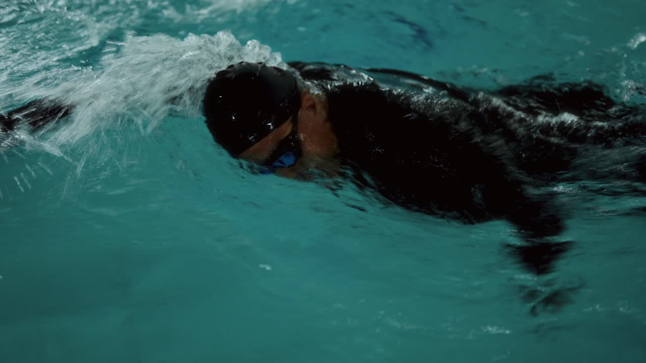 A person swimming in a pool with splashes