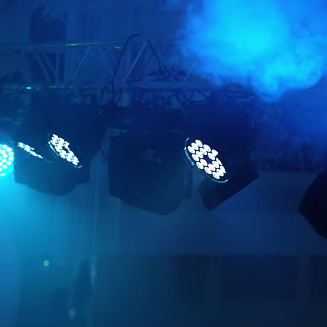 bright lights from the projector shining on the colored background. projector lens lightning and white smoke at the club party indoors.