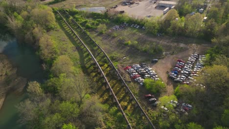 Aerial-view-of-Junk-Yard,-old-abandoned-cars-parked-in-rural-area,-circle-pan