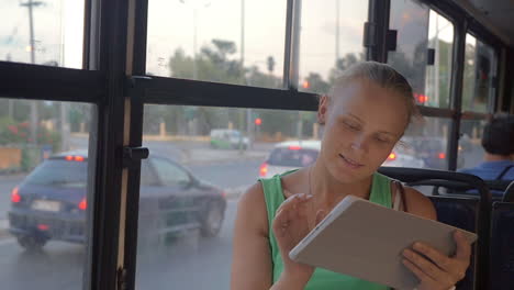 Mujer-Joven-Con-Panel-Táctil-Viajando-En-Autobús.