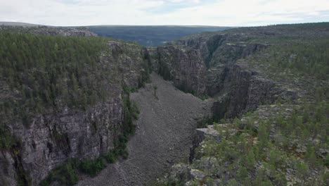 A-dolly-in-drone-shot-of-a-scree-field-in-Norway's-Jutulhogget-canyon