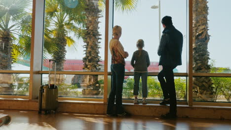 una familia de cuatro mira el avión en la terminal 1 del aeropuerto