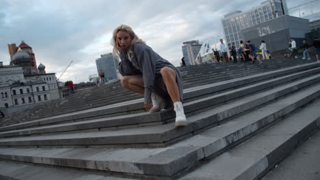 cool girl sitting pose in beautiful city centre or downtown.