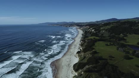 Luftaufnahme-Der-Wunderschönen-Nordkalifornischen-Küste-Mit-Meereswellen-Und-Grünen-Bergen