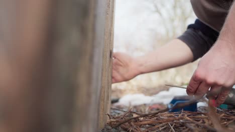 cropped view of a man screwing wood plank by cordless screw driver