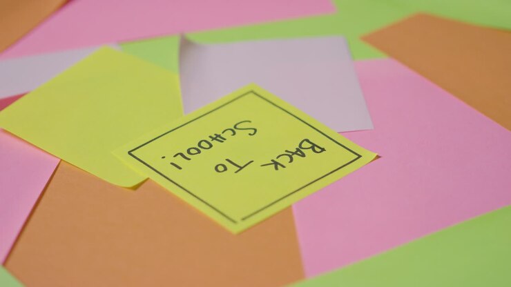 Concetto educativo di post-it girevoli con "Ritorno a scuola" scritto sul foglietto in alto 1