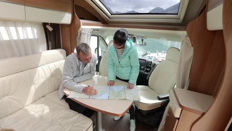 couples in rv camper looking at the local map for the trip.