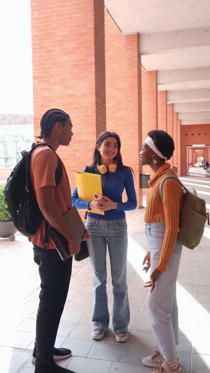 Studenti universitari felici e di diverse etnie che parlano e ridono nel campus