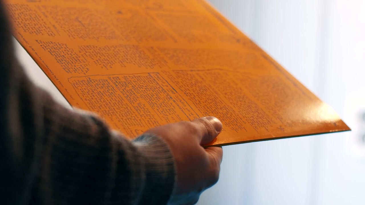 Tirare fuori un disco in vinile giallo dalla sua copertina due volte.