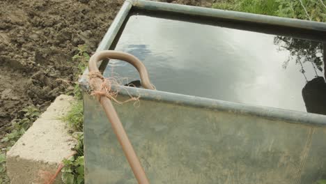 shepherd's staff outside a basin with water in the farm - dolly-in shot