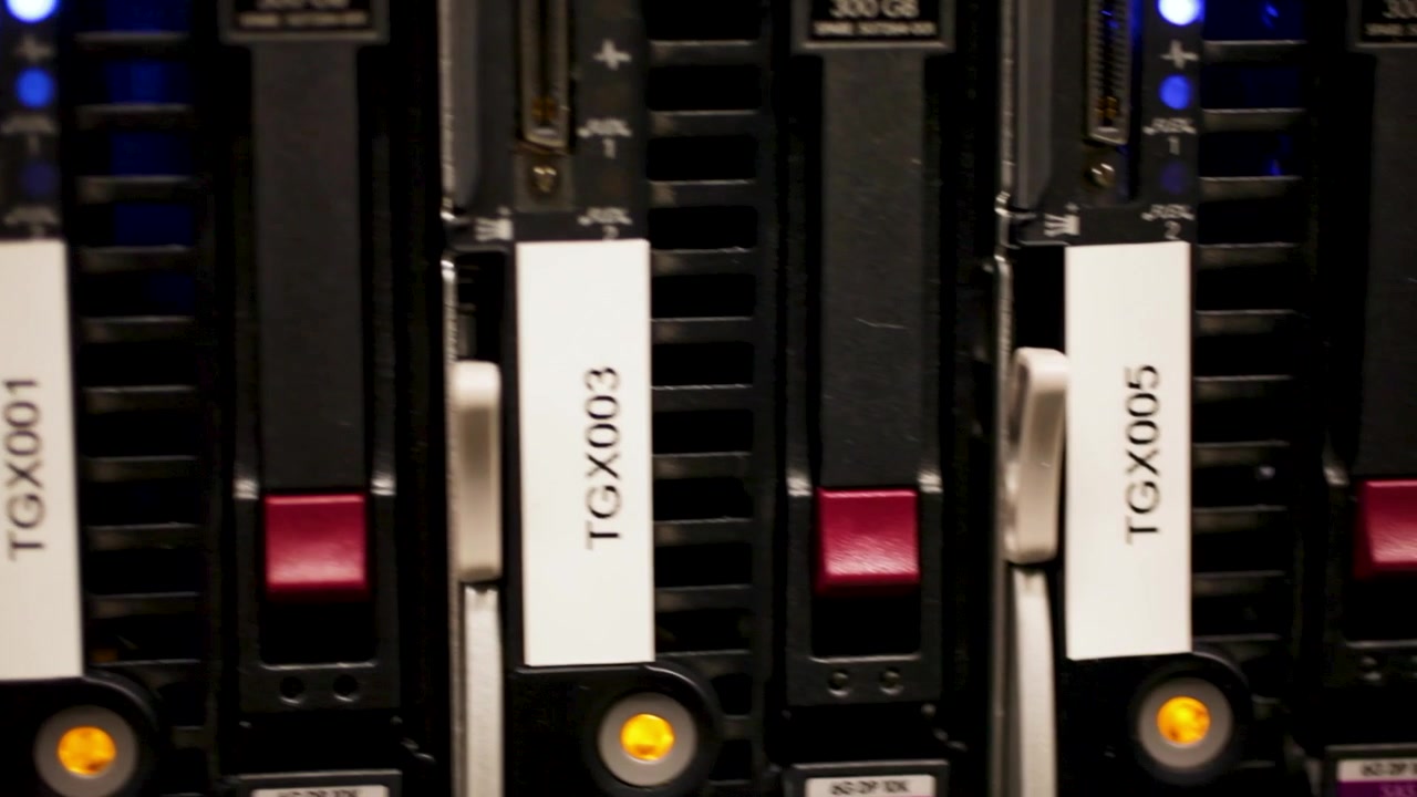 Close-up of server hard drives with blue indicator lights, labeled TGX001 and TGX003