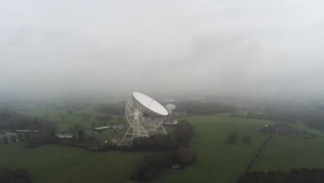 Aerial-Jodrell-bank-observatory-Lovell-telescope-misty-rural-countryside-pull-away-tilt-up