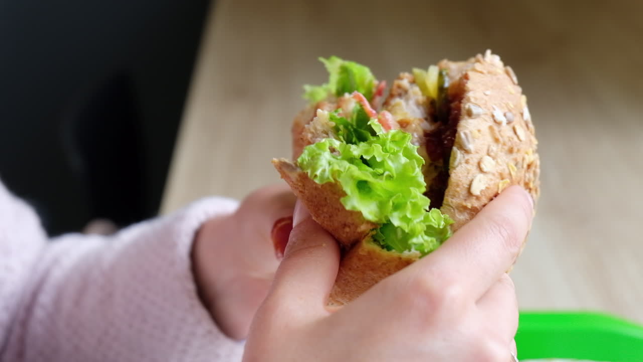 Close up of a woman eating a home made hamburger