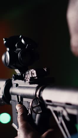 vertical video man holds rifle, enjoying shooting experience in firing range, close up