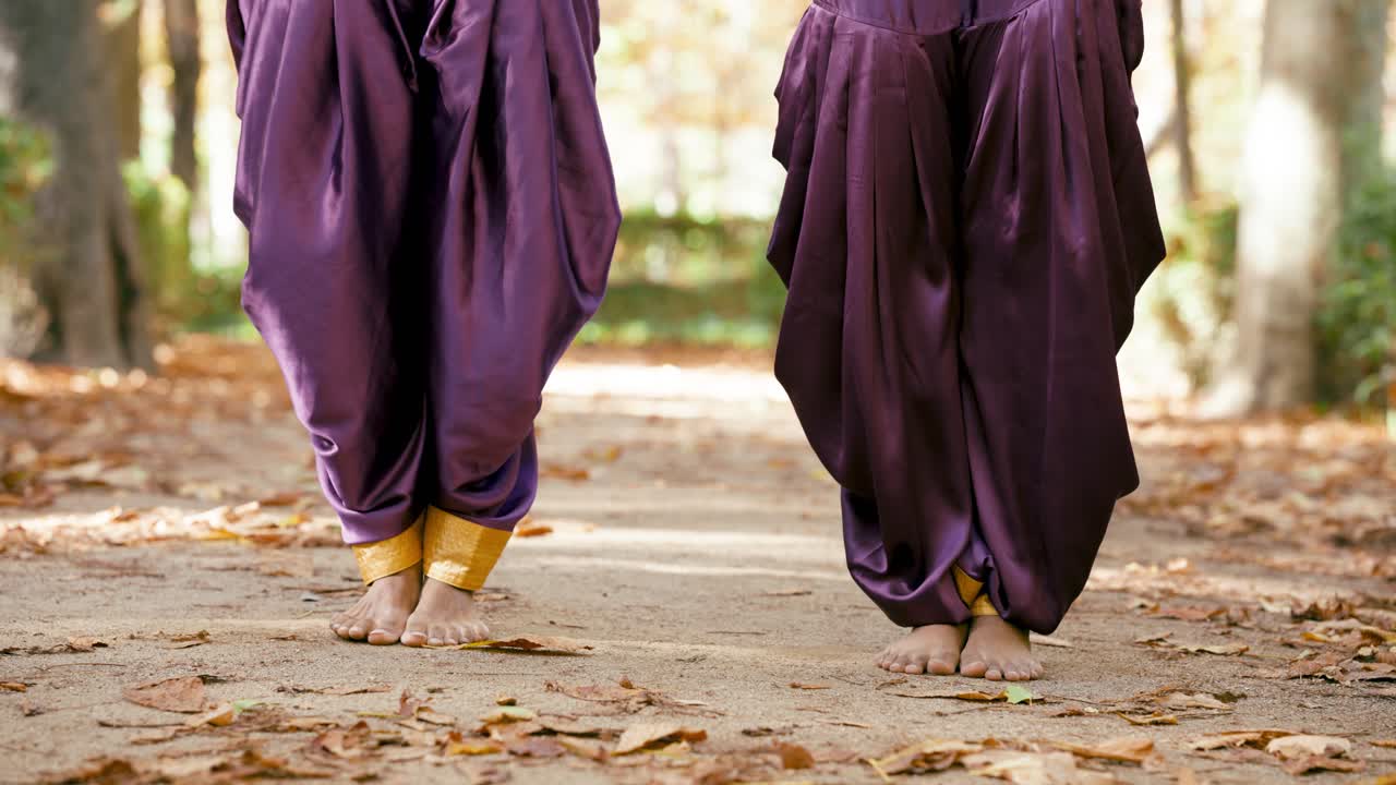 Persone che ballano a piedi nudi con pantaloni harem all'aperto