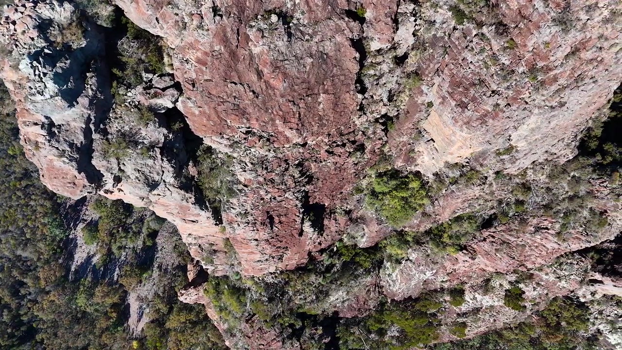 Ripresa aerea con drone di scogliere rocciose e vegetazione rada nel Parco Nazionale Warrumbungle, Australia