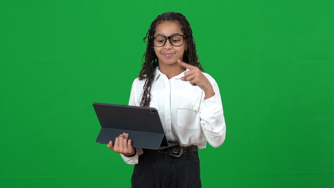 genial adolescente afroamericano usando tableta mostrando que tengo una idea gesto en pantalla verde retrato de adolescente inteligente feliz con gafas posando en fondo chromakey inteligencia y educación