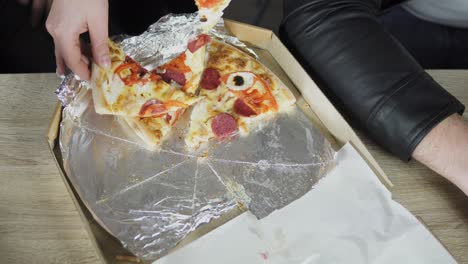 close-up of people hands taking slices pizza from food delivery open box. tasty service to office. focus changes on hands. shot in 4k